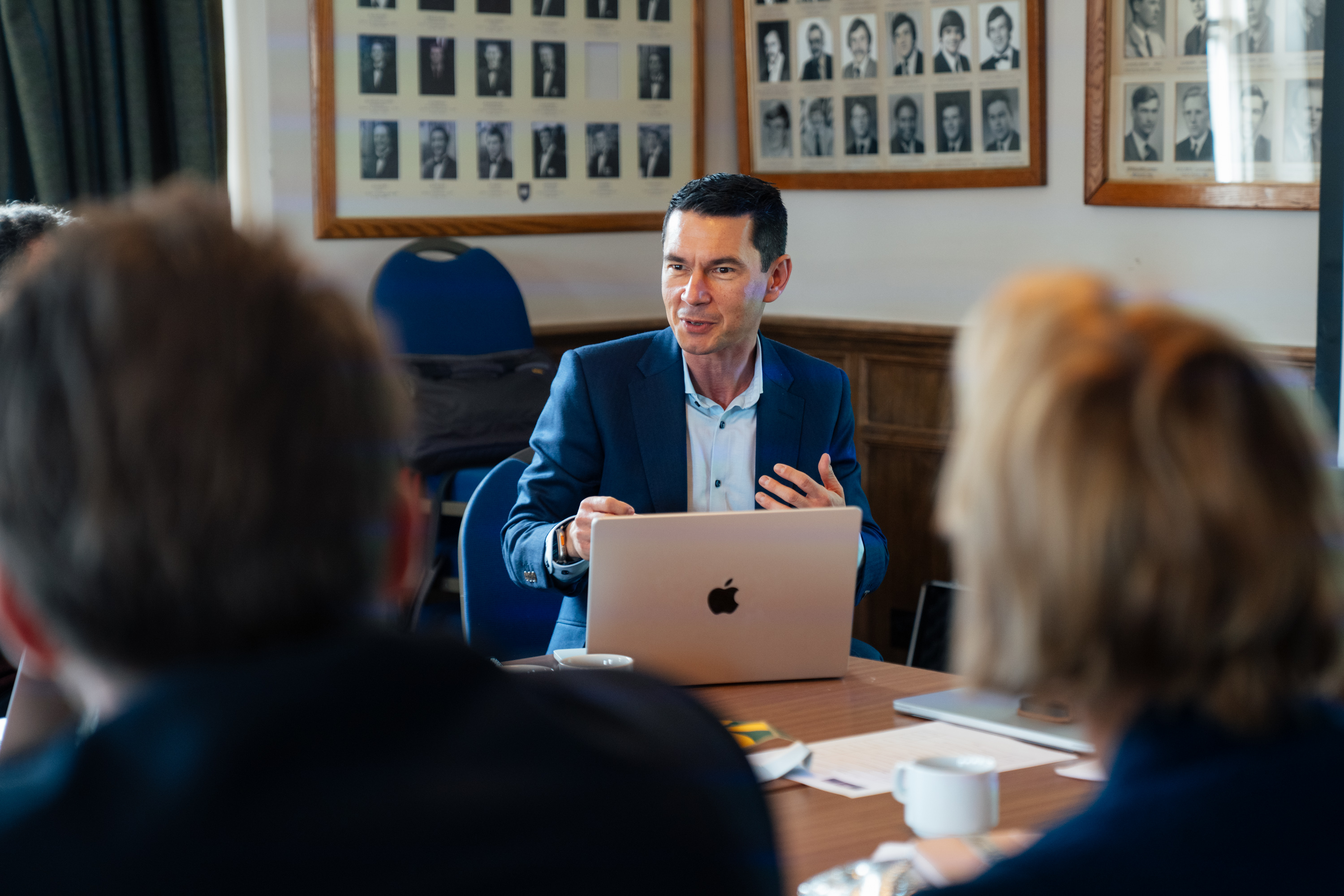 Lyndon Drake at a desk talking to meeting attendees